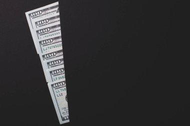 Yüz dolarlık banknotlar kısmen siyah bir arkaplanda görünür, kopyala yapıştır.