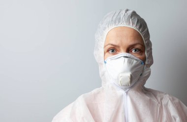 Maskeli ve koruyucu elbiseli kadın, koruma konsepti, yakın plan, kopyalama alanı.
