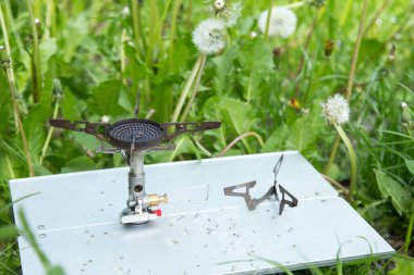 Çimlerdeki küçük bir masada turist gazı ocağı..
