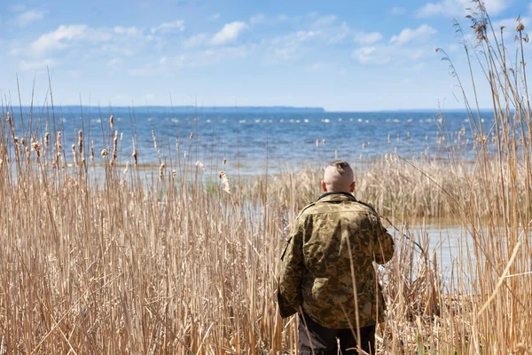 Чоловік дивиться на велику річку з очерету, вид ззаду . — стокове фото