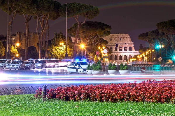Coliseum in the night with police car — Stock Photo, Image