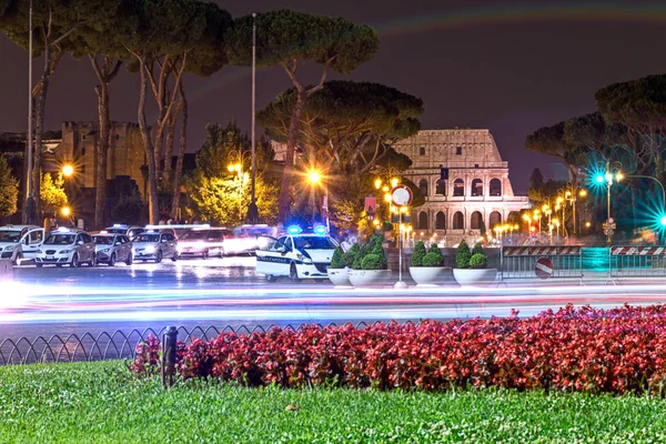 Coliseum di malam hari dengan mobil polisi — Stok Foto