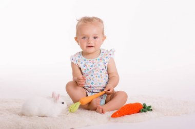 sevimli sarışın mutlu gülümseme yürümeye başlayan samimi studio a evde beslenen hayvan adatavşanı ile oynayan beyaz zemin üzerine ateş 