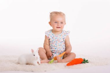 mutlu todler oturan sarışın kızla, stüdyo beyaz zemin üzerine vurdu. 