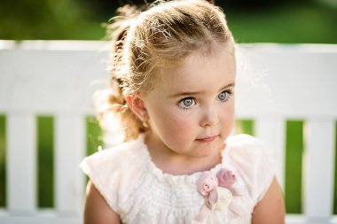 Güzel, doğal bir bahçe bahçesinde uzun saçlı küçük bir kız. Bir yaz günü kedi yavrusuyla elma bahçesi.