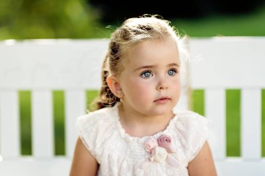 Güzel, doğal bir bahçe bahçesinde uzun saçlı küçük bir kız. Bir yaz günü kedi yavrusuyla elma bahçesi.