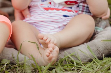 Çıplak bebek ayaklarıyla bahçedeki yeşil çimlerle 