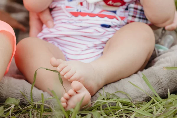 bare baby feet outside with green grass in a garden park