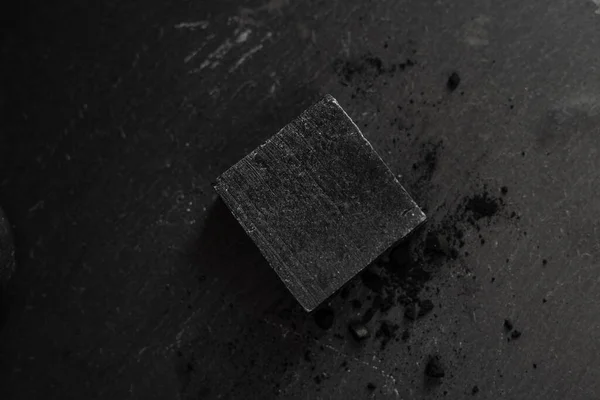 Black carbon charcoal soap on a black granit background