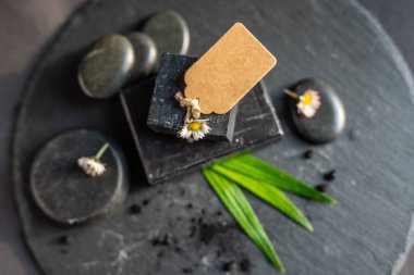 kömür kömürü karbon siyah sabun çubuğu çiğ ahşap bambu arkaplan lav taşı kaplıca cilt hijyen konsepti. Siyah siyah taş sırtüstü. Çiğ ahşap arka plan lav taşı kaplıca cilt hijyen konsepti