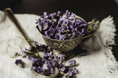 Mor viyola keman çiçeğine yakın seramik siyah bir çanakta çiçek başları