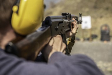 Polis eğitiminde tüfekli bir adam hedefe nişan alıyor.