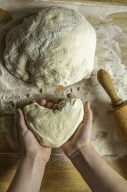 Çocuklarla yemek pişirmek maya un hamuru pişirmeye yardım etmek ahşap tahtada kalp şeklinde yükseliyor.