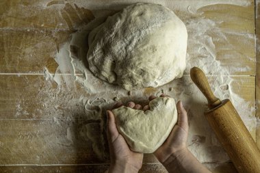 Çocuklarla yemek pişirmek maya un hamuru pişirmeye yardım etmek ahşap tahtada kalp şeklinde yükseliyor.
