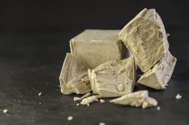 Beyaz bir mutfak zemininde ahşap oklamalı kuru ve taze bir maya.