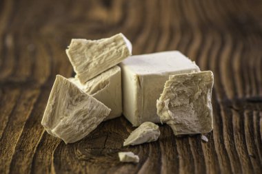 Beyaz bir mutfak zemininde ahşap oklamalı kuru ve taze bir maya.