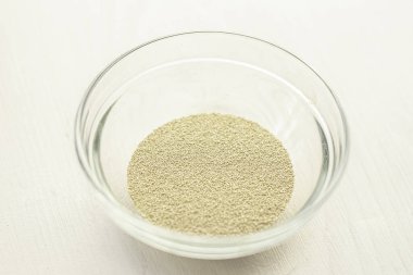 Beyaz bir mutfak zemininde ahşap oklamalı kuru ve taze bir maya.