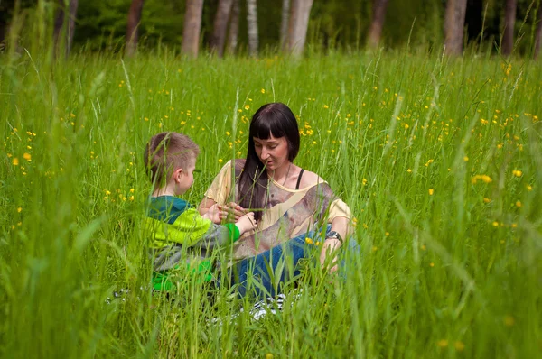 少年と緑の草の母 — ストック写真