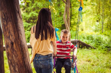 Anne ve çocuk salıncak üzerinde