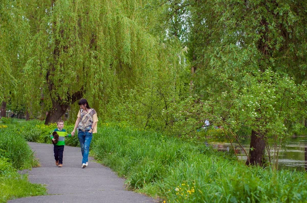 少年と緑の草の母 — ストック写真