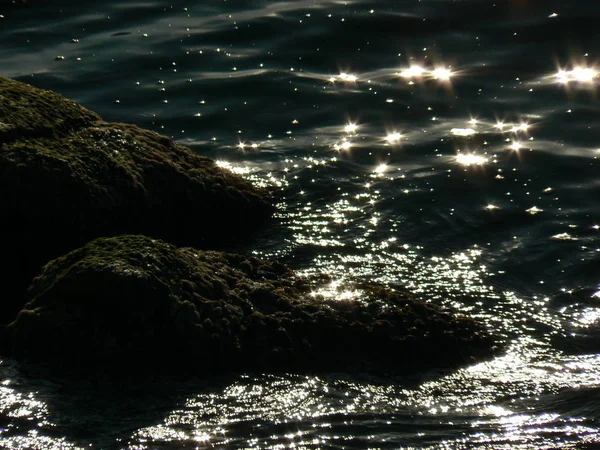 mysterious shine of the sun on water and rocks