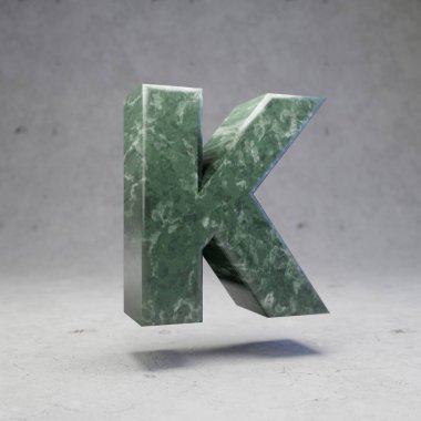 Yeşil mermer harf K büyük harf beton arka planda. 3d biçimlendirilmiş parlak taş yazı tipi karakteri.