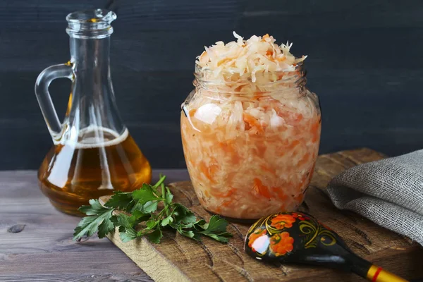Jar of sauerkraut on wooden board and bottle of oil — Stock Image Jar of sauerkraut on wooden board and bottle of oil Stock Picture