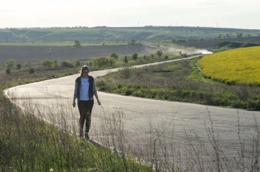 Kız bir viraj ile karayolu üzerinde yürüyüş