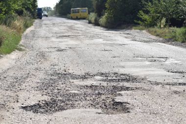 Çukurlar ve çukurlar ile kırık bir yolda trafik