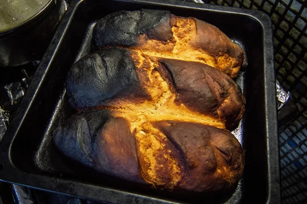 Pan quemado al hornear en una bandeja negra para hornear — Foto de Stock