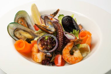 Beyaz tabakta taze deniz ürünleri salatası