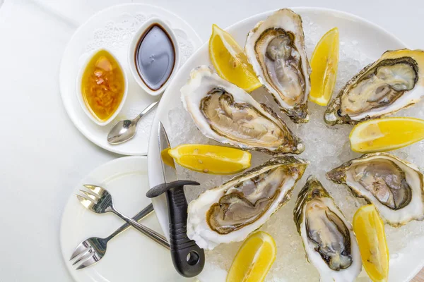 Ostras frescas en un plato con limón —  Fotos de Stock