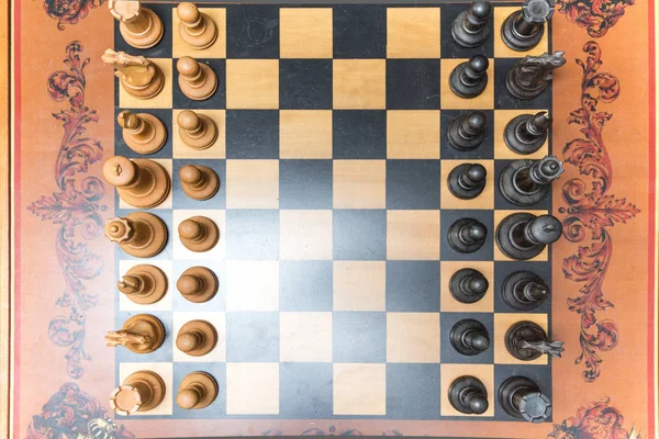 Деревянные шахматные фигуры на открытой шахматной доске в солнечный день, король в фокусе — стоковое фото
