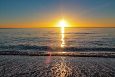 denizin üzerinde yükselen güneş