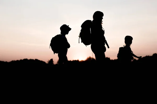 Silhouetten van moeder en kinderen wandelen — Stockfoto