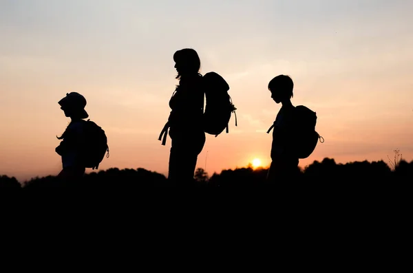 Çocuklarıyla birlikte günbatımında hiking anne siluetleri — Stok fotoğraf