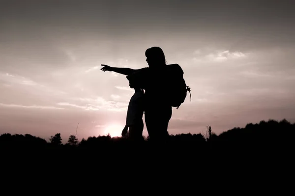 Silhouet van woman wijzend in de verte bij zonsondergang — Stockfoto