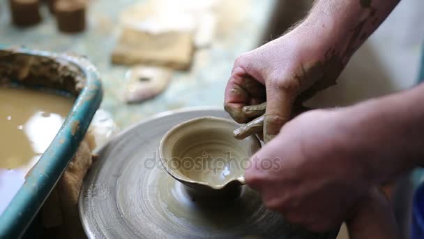 Старший гончар учит счастливого маленького мальчика искусству керамики — стоковое видео