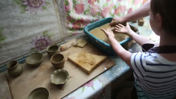 Flicka hennes smutsiga handtvätt efter att skapa lera skål på ett skulptera hjul — Stockvideo