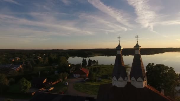 Vista aérea de um mosteiro antigo pitoresco na costa do lago no céu excelente e nuvens no por do sol — Vídeo de Stock