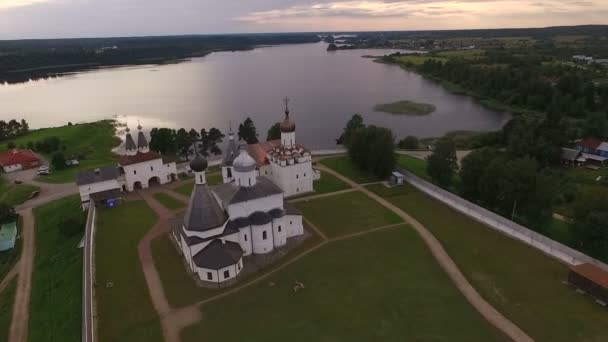 Luchtfoto van oude schilderachtige klooster gelegen op de oever van het meer bij zonsondergang — Stockvideo