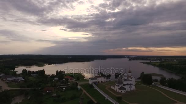 Вид на стародавній мальовничий монастир на березі озера на заході сонця — стокове відео