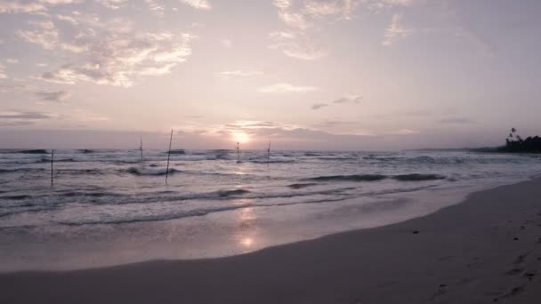 在印度洋海岸附近的传统钓鱼竿上的渔民在日落时在一个废弃的沙滩上的声音 — 图库视频影像