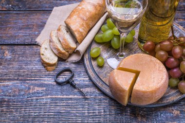 Beyaz şarap bir şişe corkcrew ve ürünler - peynir, üzüm, fındık, zeytin, incir ahşap bir gemide bir dizi arka plan