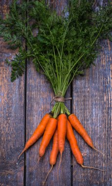 Ahşap arka plan üzerinde bir pakette bulunan havuç