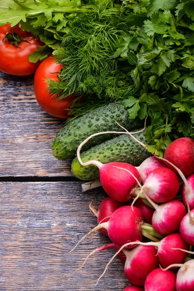 Збирання Овочі: помідори, огірки, цибуля, часник, рукола, редька на дерев'яному тлі — стокове фото
