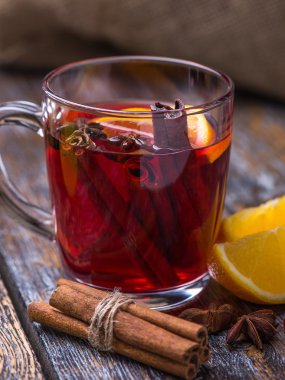 Sıcak bir içecek, sıcak kırmızı şarap cam, kartopu, tarçın, portakal ahşap arka plan üzerinde bir fincan