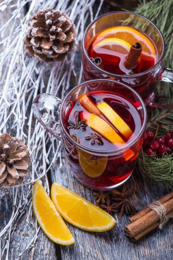 Sıcak bir içecek, sıcak kırmızı şarap cam, kartopu, tarçın, portakal ahşap arka plan üzerinde bir fincan
