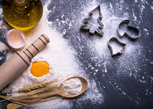 Galletas de Navidad. Ingredientes para hornear: masa, harina, formas para galletas sobre fondo de madera — Foto de Stock