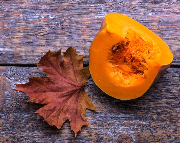 Zucca e foglie di autunno su uno sfondo di legno vecchio — Foto Stock